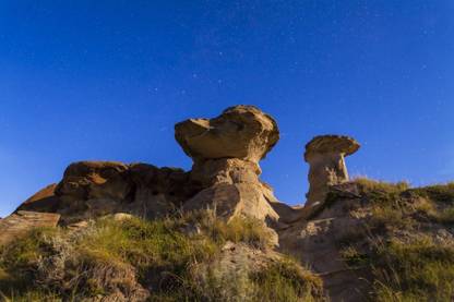 Starry sky above hoodoo formations at Dinosaur Provincial Park Canada Canvas Art