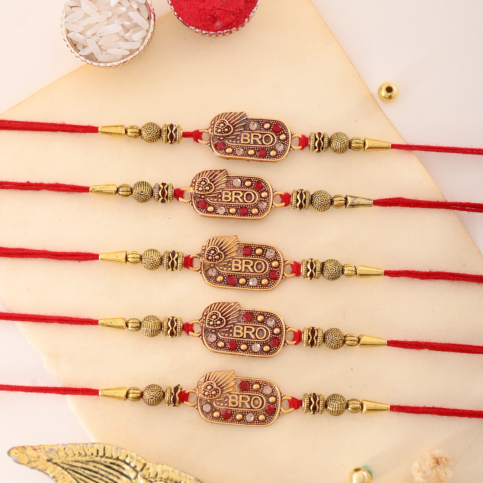 be unique Designer MBRO RAKHI PACK OF 5 A Gold Finish Rakhi, Chawal Roli Pack Set image 1